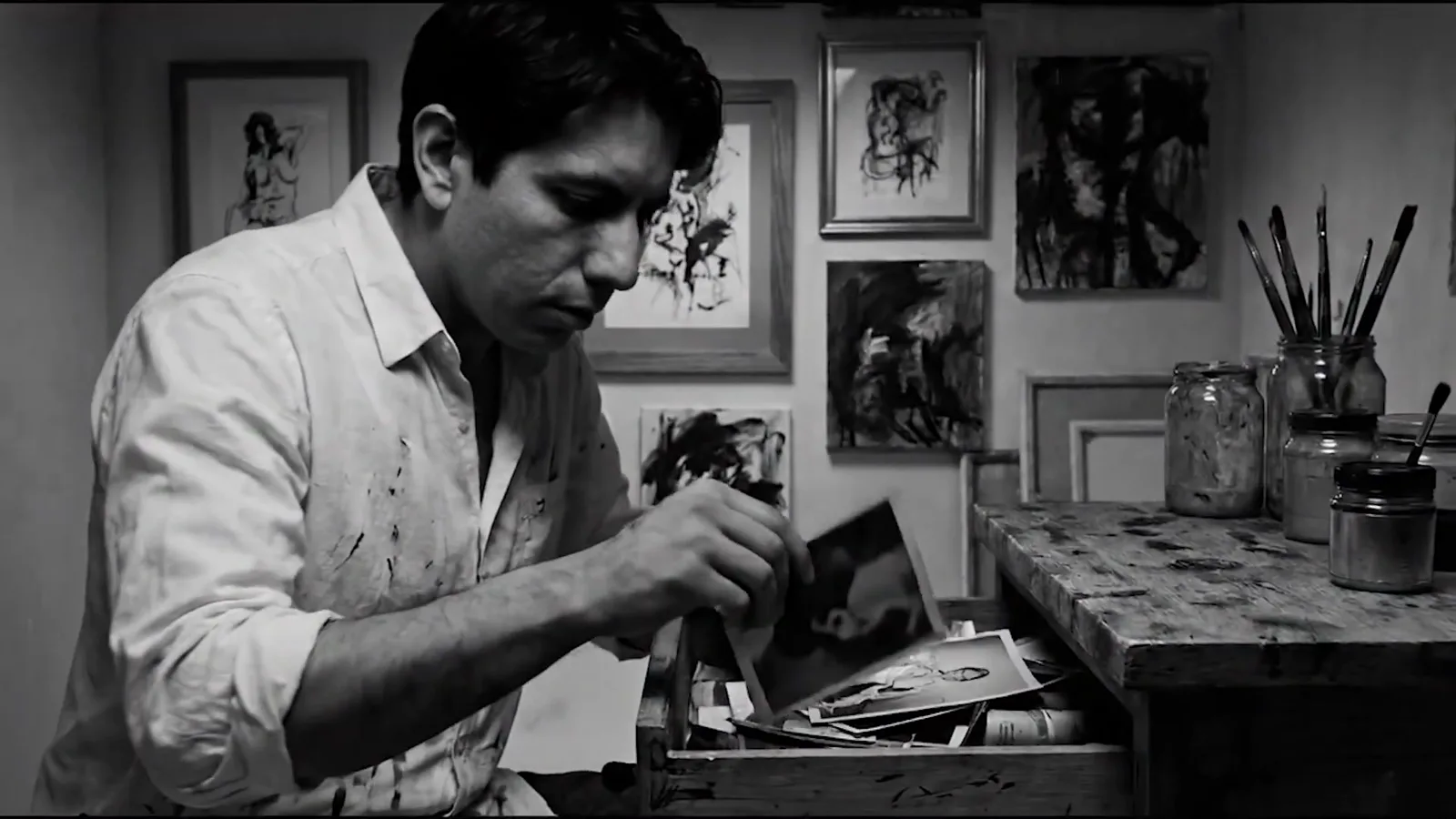 el pintor abre el cajón que contiene la vieja fotografía